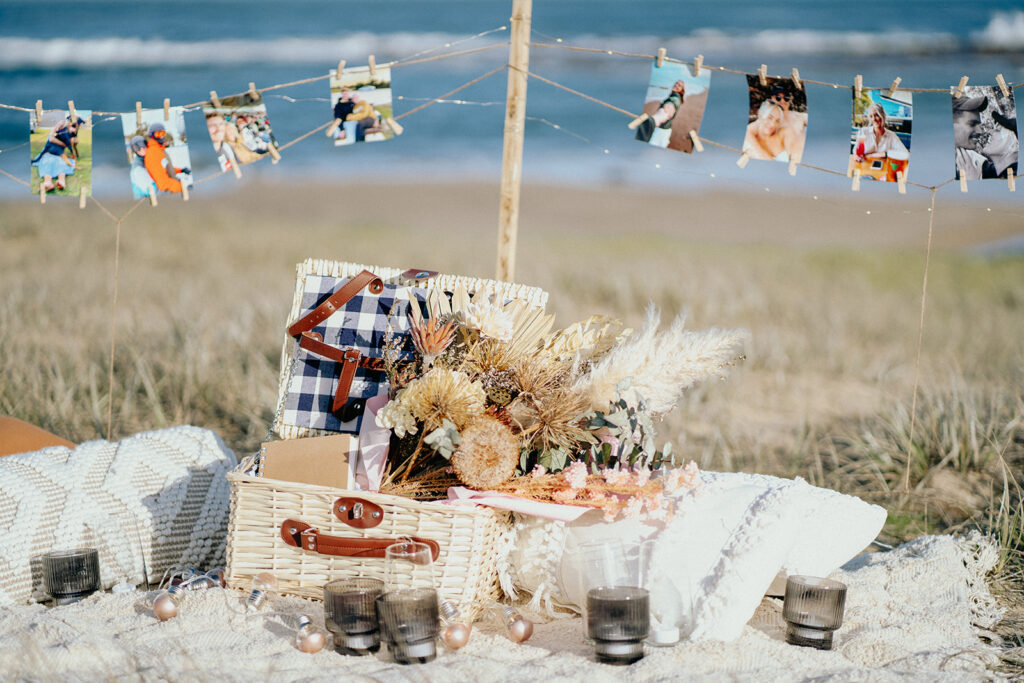 proposal picnic at the beach ideas and inspiration, sentimental with photos, candles, flowers a letter and fairy lights