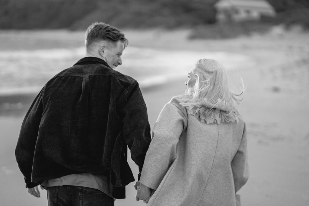 Sunset engagement session on the beach at Cape Paterson, couple running together hand in hand after getting engaged, black and white