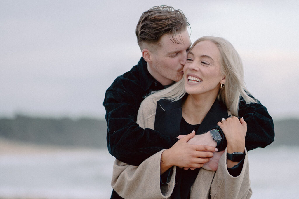 Sunset engagement session on the beach at Cape Paterson, couple laughing and holding each other - 6