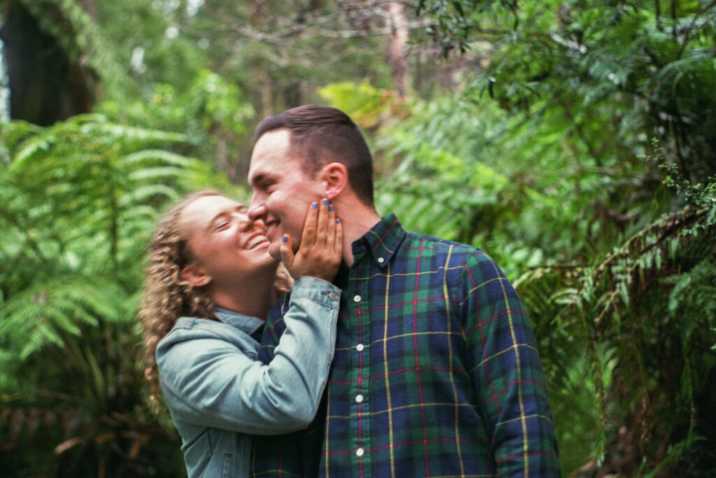 A couple canoodling during their forest engagement session 