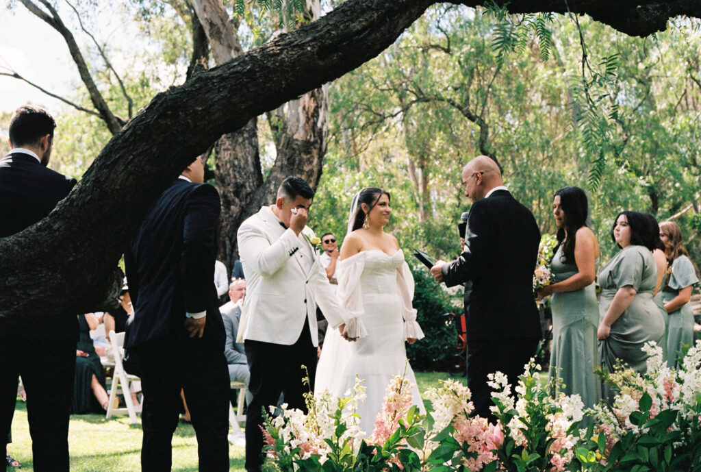 Groom wiping away his tears during his wedding ceremony at emu bottom homestead, captured on 35mm film