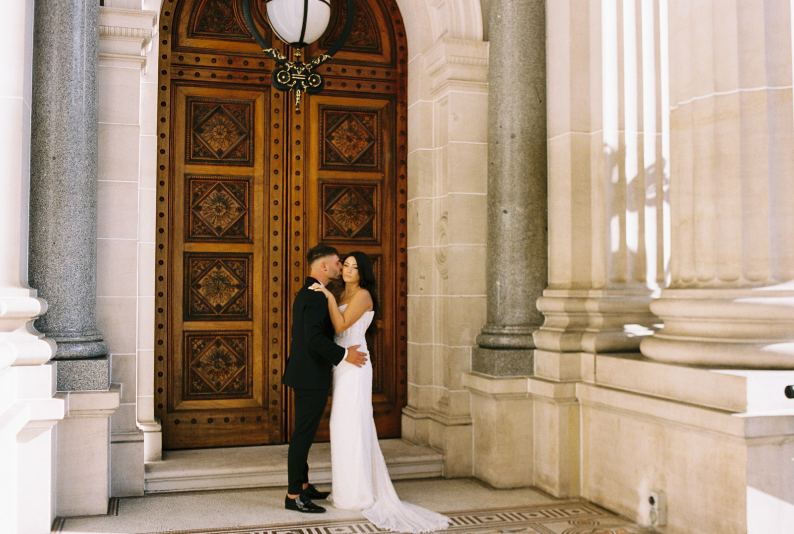 Bride and groom on their wedding day, taking photos at parliament house in melbourne city