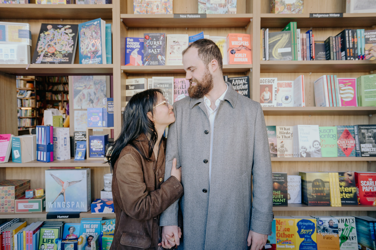 Nicole and and Matt holding hands in front of a bookstore