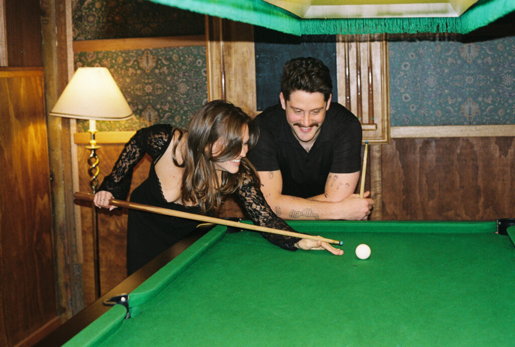 a couple laughing together while they play pool