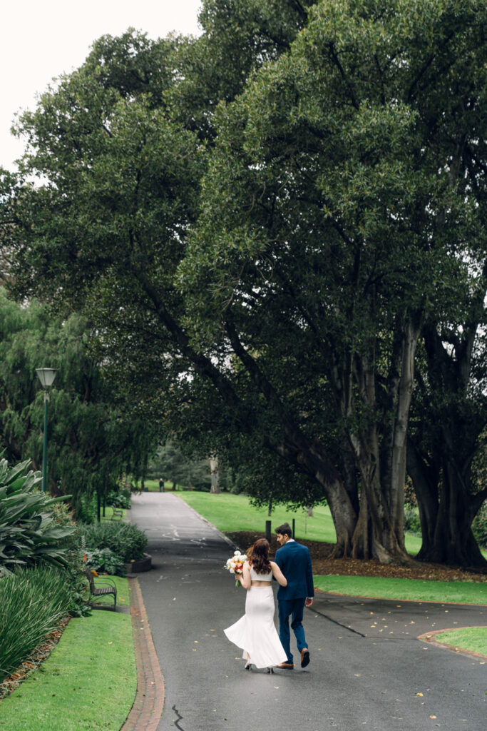 bride and groom walking together through the Treasury gardens