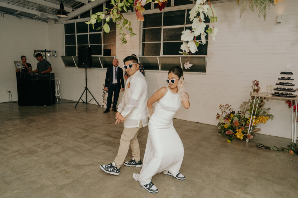 Bride and Groom with white heart sunglasses and panda dunks during their wedding reception entrance