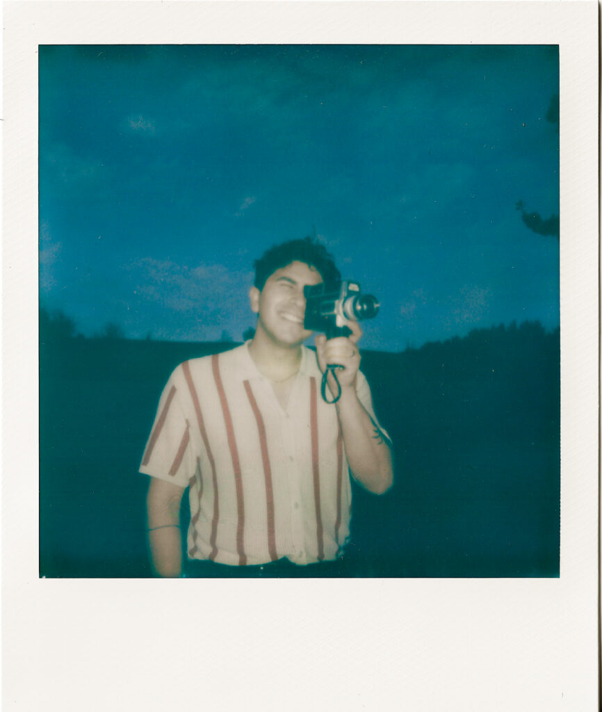 man holding a super 8 camera and looking through the view finder