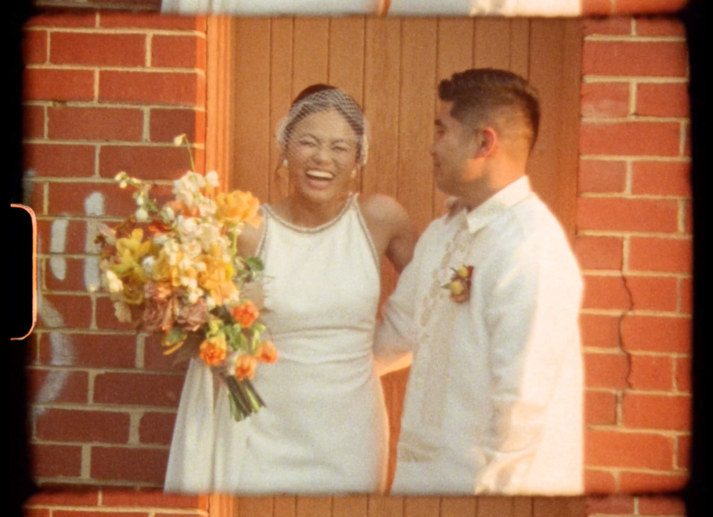 a super 8 film snippet of a couple laughing together on their wedding day