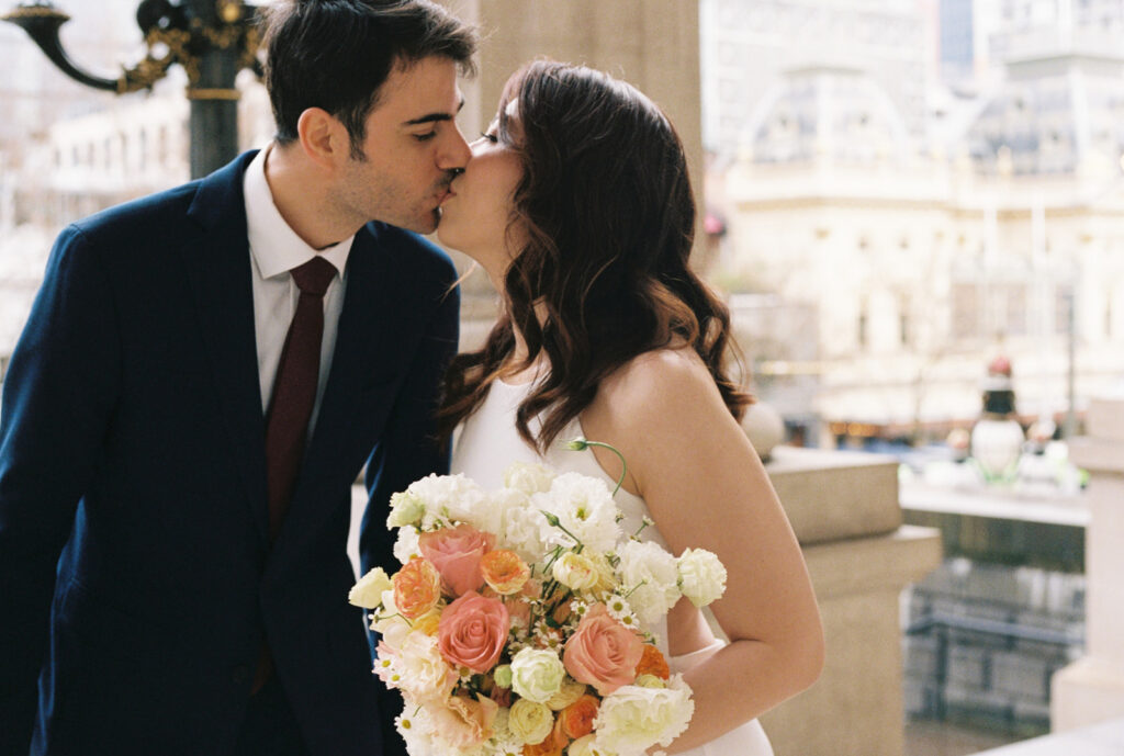 a film photo of a couple kissing on their wedding day at the parliament house