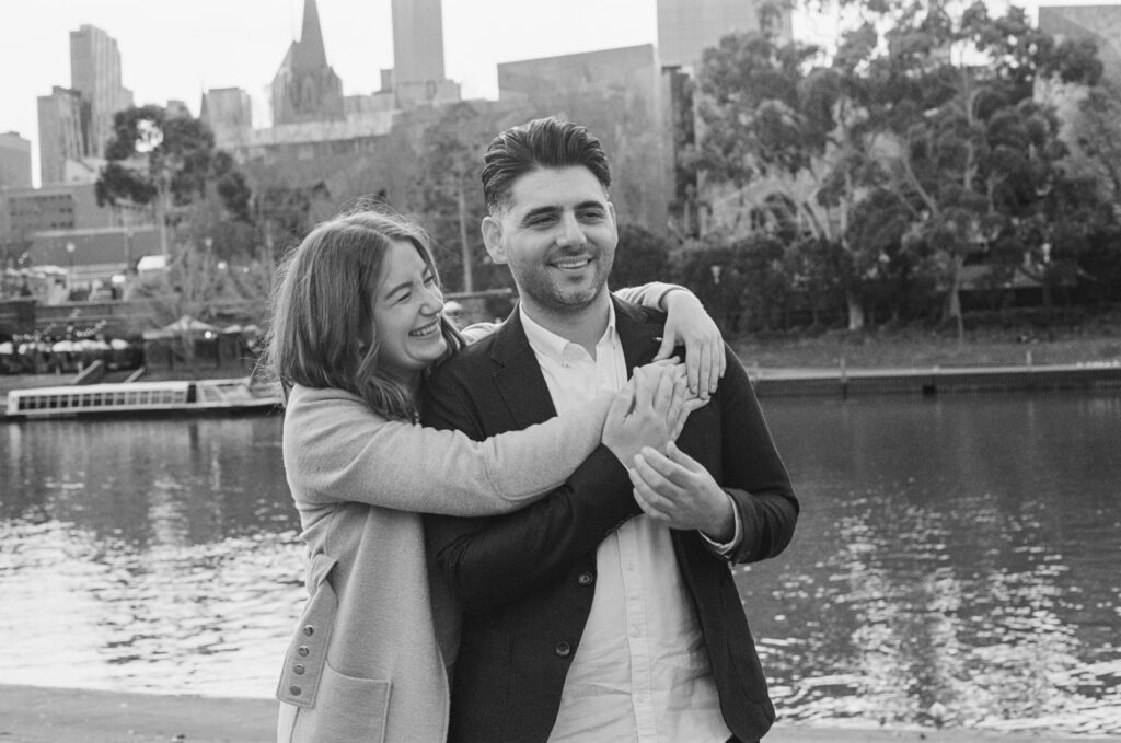 A black and white 35mm photo of a couple hugging in melbourne city during their engagement photos