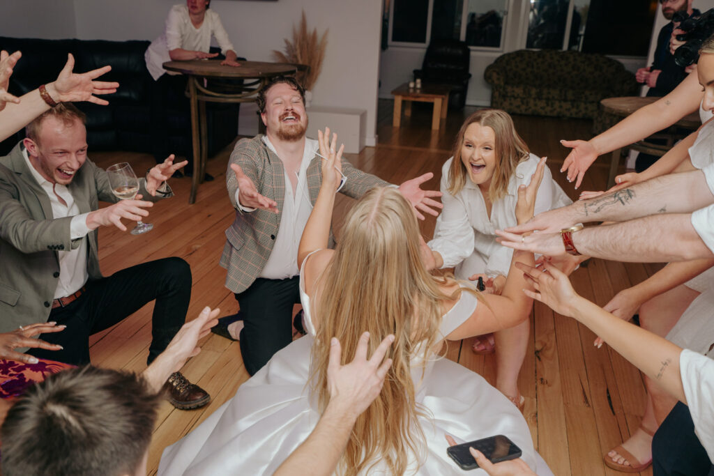 a bride on the dancefloor and everyone is pointing towards her