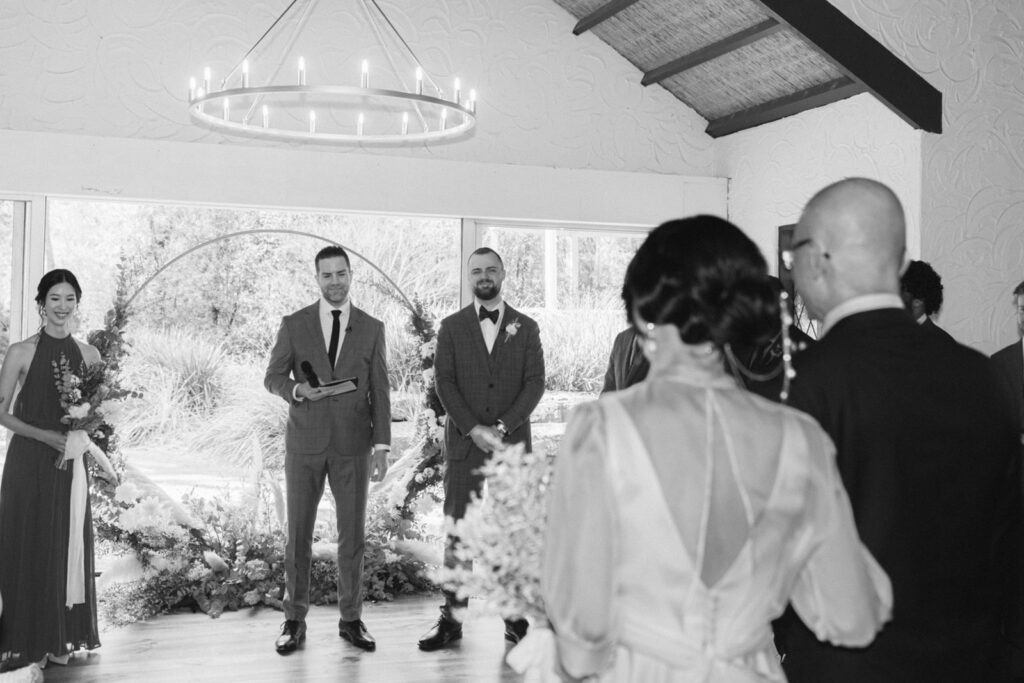 a black and white photo of the bride meeting the groom at the altar of the potters receptions chapel