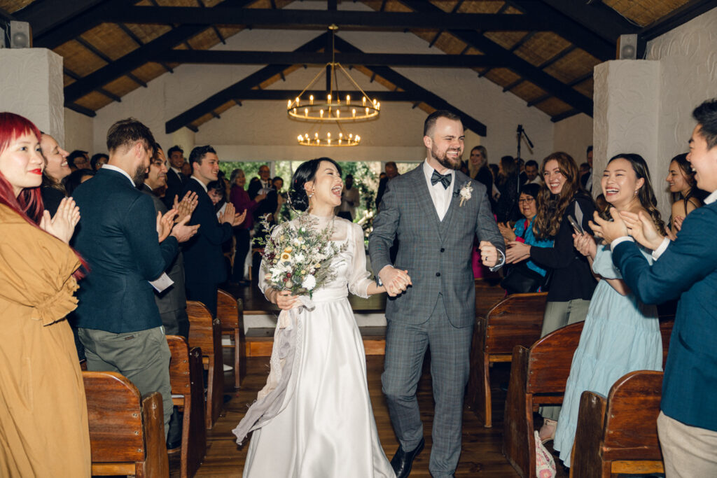 bride and groom celebrating and walking down the aisle of the chapel