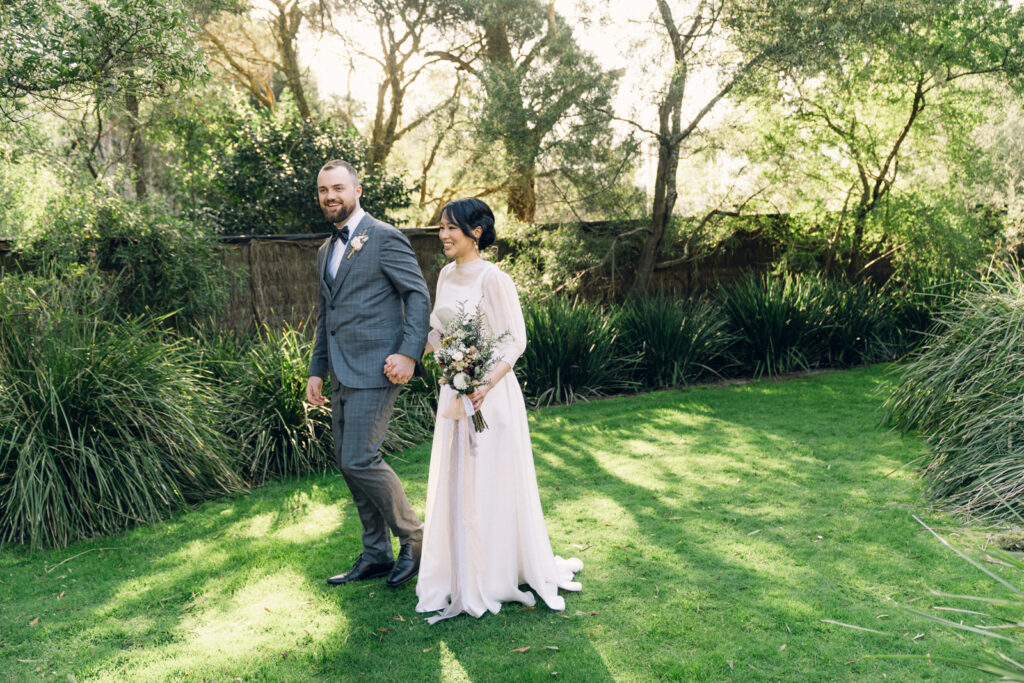 bride and groom holding hands in the potters receptions garden