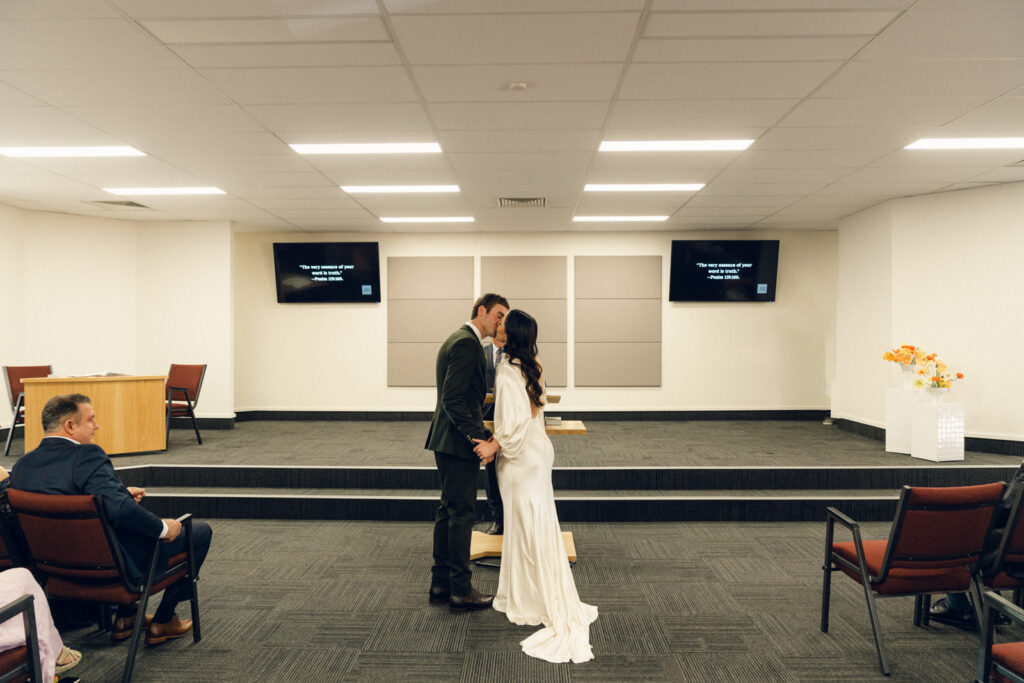 bride and grooms first kiss at their wedding ceremony