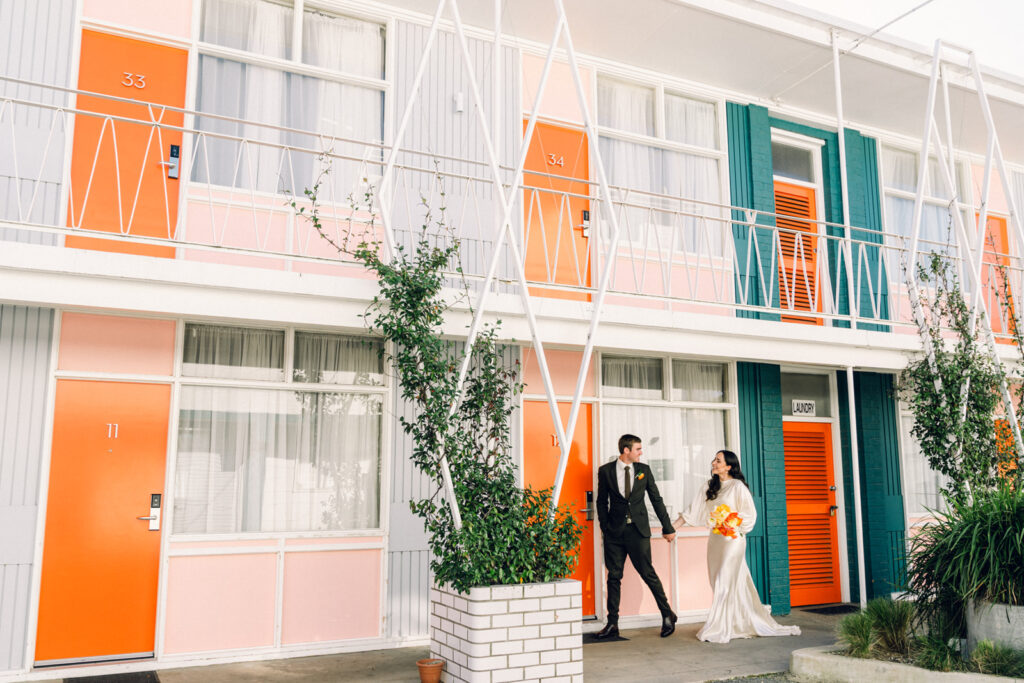 bride and groom walking through the astor motel together