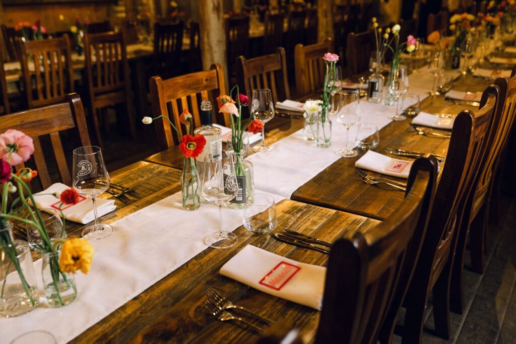 rustic venue with colourful bud vases table setting