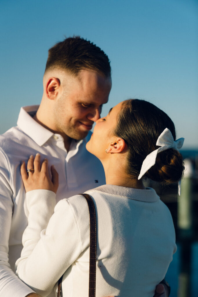 a couple touching noses during their sunset beach engagement session