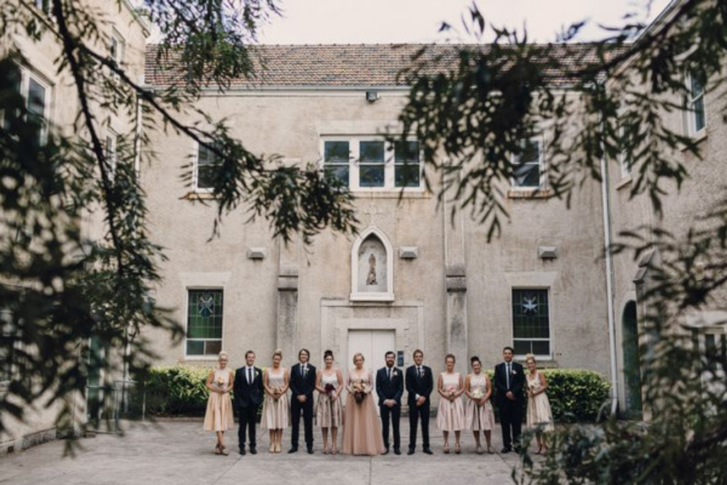 a bridal party standing outside the exterior of the abbotsford convent