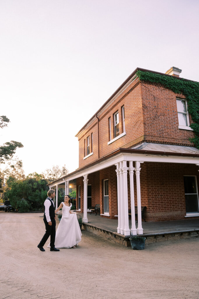 Bride and groom in front of the main house at Ravenswood Homestead on their wedding day