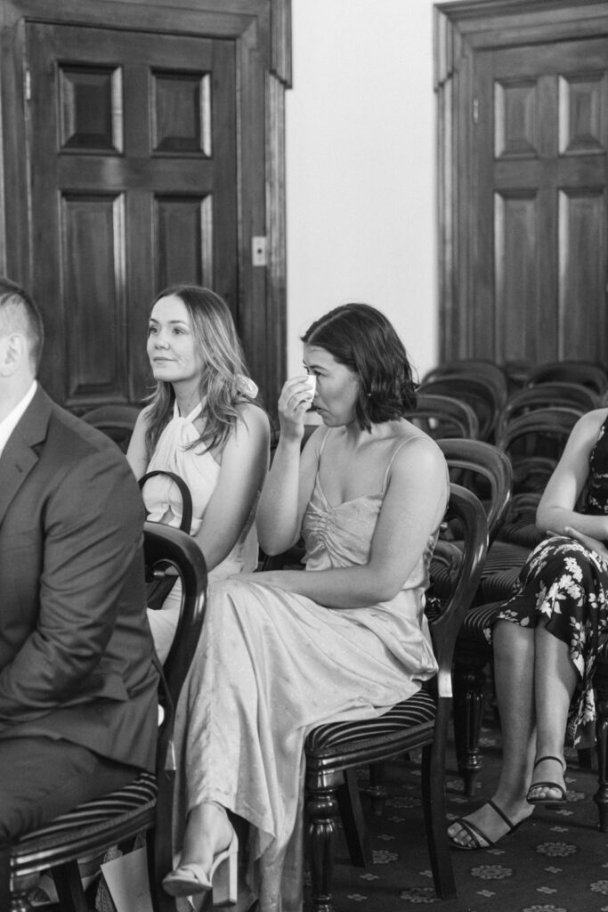 black and white photo of a wedding guest wiping away tears during an elopement