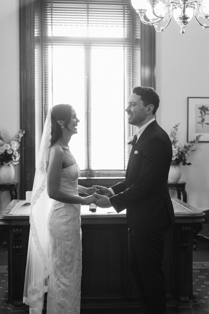 black and white photo of a bride and groom during their wedding ceremony at the melbourne marriage registry office