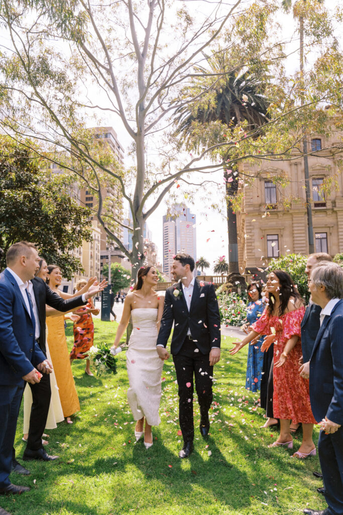 bride and groom walking through rose petals after their wedding ceremony