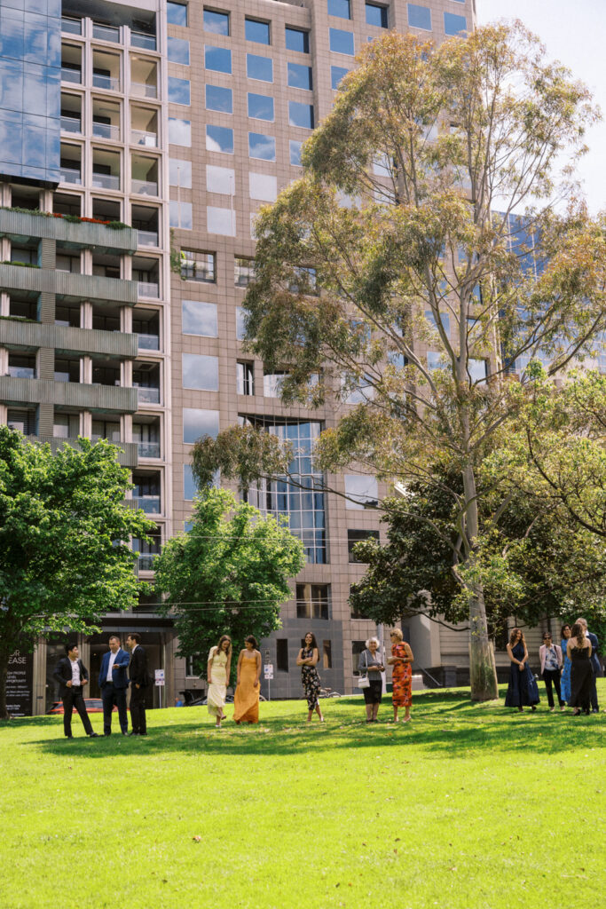 wedding guests waiting in the shade outside 