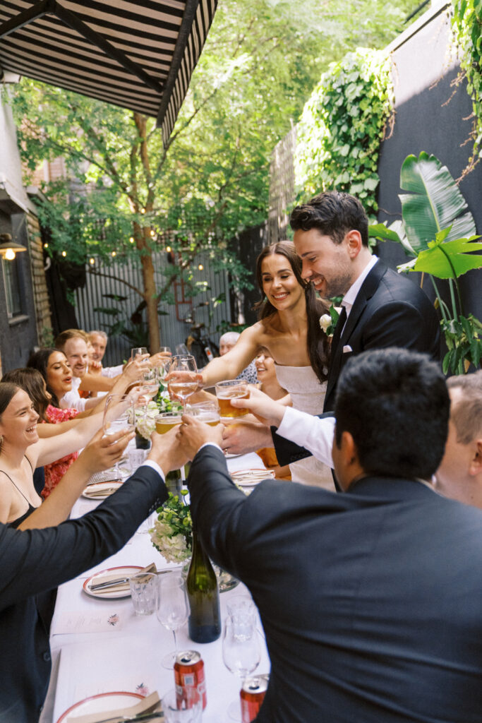 bride and groom toasting with their closes wedding guests 