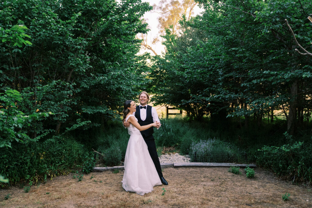 bride and groom dancing together in the garden of Ravenswood Homestead