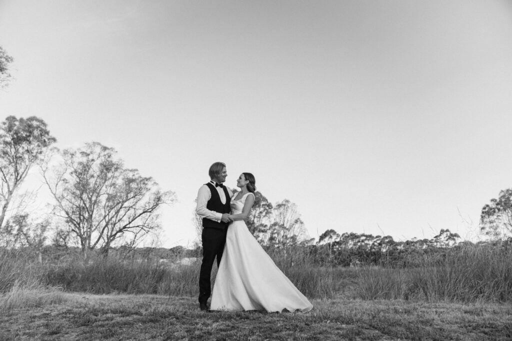 black and white photo of bride and groom on a hilltop