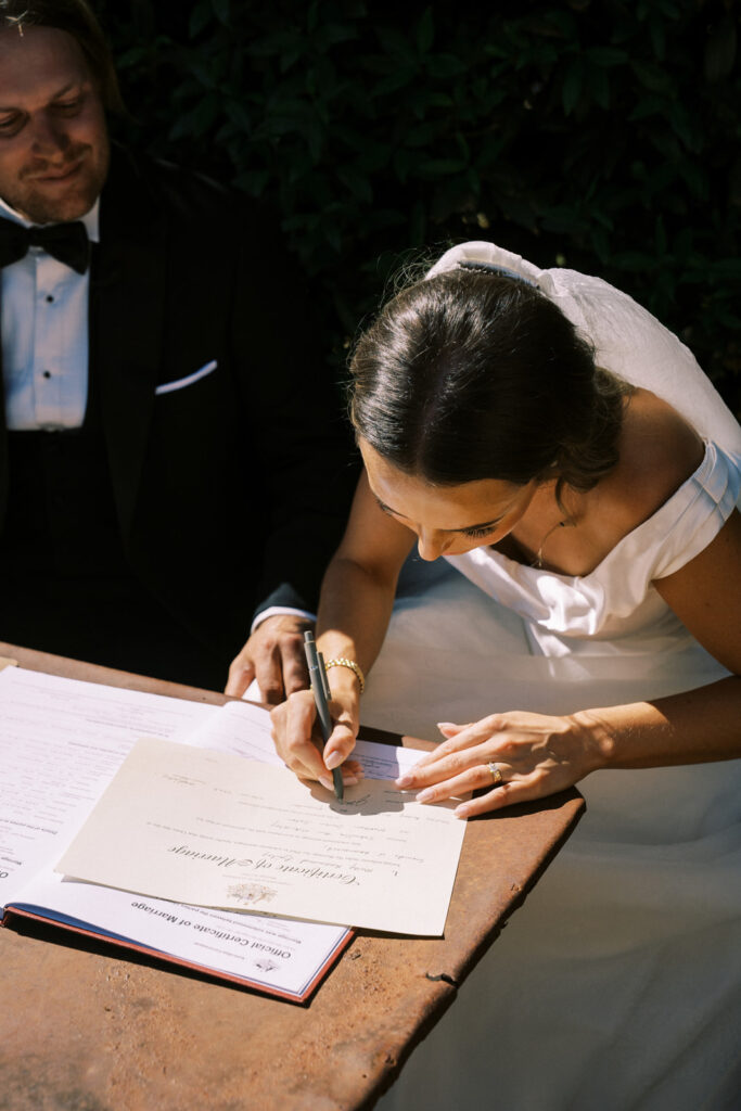 bride signing their wedding certificate